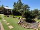 Backyard featuring a stream and bridge, surrounded by mature trees and artificial turf at 2312 Indigo Island St, Henderson, NV 89044
