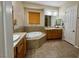 Bathroom featuring double sinks, a soaking tub, and tile flooring and half-wall at 2312 Indigo Island St, Henderson, NV 89044