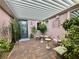 Cozy front patio area featuring shaded seating, lush plants, and a decorative pergola at 2312 Indigo Island St, Henderson, NV 89044