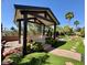 Backyard gazebo with beautiful landscaping around it, complete with green grass and tropical plants at 2312 Indigo Island St, Henderson, NV 89044