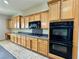 Functional kitchen featuring wood cabinetry, modern black appliances, and ample countertop space at 2312 Indigo Island St, Henderson, NV 89044