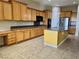 Kitchen with island, oak cabinets, modern appliances, and tile flooring at 2312 Indigo Island St, Henderson, NV 89044