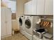Well-organized laundry room with white cabinetry, modern washer and dryer, and ample storage space at 2312 Indigo Island St, Henderson, NV 89044