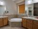Main bathroom featuring dual sinks, and a large soaking tub set in tile surround at 2312 Indigo Island St, Henderson, NV 89044