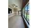 Long enclosed patio with tiled floor, ceiling fans, and large windows overlooking a landscaped backyard at 2312 Indigo Island St, Henderson, NV 89044