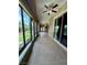 Long sun room with ceiling fans and a wall of windows overlooking the landscaped yard at 2312 Indigo Island St, Henderson, NV 89044