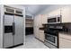 Kitchen with cream cabinets, stainless steel appliances, and adjacent laundry area at 2631 Bed Knoll Ct, North Las Vegas, NV 89031