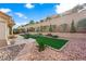 Backyard with artificial turf, surrounding rocks, patio and BBQ area at 2725 Byron Dr, Las Vegas, NV 89134