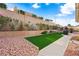 Manicured backyard with turf and rock landscaping, providing low maintenance charm at 2725 Byron Dr, Las Vegas, NV 89134