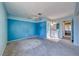 Well-lit bedroom with neutral carpet, complemented by blue accents and a ceiling fan at 4100 Montebello Ave, Las Vegas, NV 89110