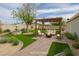 Backyard area with a pergola, comfortable seating, fire pit, water fountain feature, and lush landscaping at 419 National St, Henderson, NV 89015