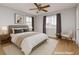 Cozy bedroom featuring neutral walls, wood-look floors, a ceiling fan, and two windows with drapes at 419 National St, Henderson, NV 89015