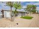 Charming home with a rockscaped yard, a small patch of artificial turf, and mature trees at 419 National St, Henderson, NV 89015
