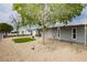 Cozy home featuring a green lawn area, mature trees, and a welcoming front porch at 419 National St, Henderson, NV 89015