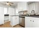 Bright kitchen with white cabinets, stainless steel dishwasher, and dark countertops at 419 National St, Henderson, NV 89015
