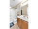 Bright bathroom with a shower over tub, wood cabinets, and tiled floors at 4195 Story Rock St, Las Vegas, NV 89115