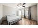 Neutral bedroom with a ceiling fan, hardwood floors, and natural lighting from windows at 4666 Plata Del Sol Dr, Las Vegas, NV 89121