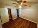 This bedroom features wood flooring, a ceiling fan with lights, and a closet with sliding doors at 4682 Tamalpias Ave, Las Vegas, NV 89120