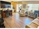 Cozy living room featuring wood floors, large TV, and comfortable seating arrangement at 4682 Tamalpias Ave, Las Vegas, NV 89120