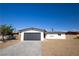 Single story home featuring a dark gray garage door, minimal landscaping and a gravel yard at 508 S Jones Blvd, Las Vegas, NV 89107