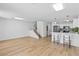 Open-concept living room with hardwood floors, adjacent to the modern kitchen and breakfast bar at 5516 Ness Ave, Las Vegas, NV 89118