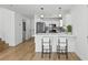 Open living space with breakfast bar, lighting fixtures, and seamless transition to kitchen at 5516 Ness Ave, Las Vegas, NV 89118