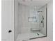 Modern bathroom features a glass enclosed shower, bench, and neutral finishes at 5516 Ness Ave, Las Vegas, NV 89118