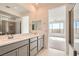 Light-filled bathroom featuring double sinks, sleek cabinets, and a tiled shower visible in the mirror at 58 Sun Lily Ln, Henderson, NV 89011