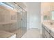 Bathroom featuring tiled shower with glass door, bench and light grey vanity with single sink at 58 Sun Lily Ln, Henderson, NV 89011