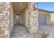Covered front porch with stone pillars and brick pavers, leading to the home's entrance at 58 Sun Lily Ln, Henderson, NV 89011
