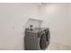 Modern laundry room with front loading washer and dryer, plus storage shelf at 58 Sun Lily Ln, Henderson, NV 89011