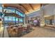 Inviting lounge area with stylish seating, a bar, a stone fireplace, and floor-to-ceiling windows with mountain views at 58 Sun Lily Ln, Henderson, NV 89011