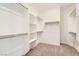 Spacious walk-in closet with neutral carpet and multiple shelving units at 58 Sun Lily Ln, Henderson, NV 89011