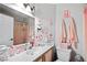 Bathroom featuring double sinks, novelty wall art, and shower with patterned curtain at 5950 Pacific Shores Dr, Las Vegas, NV 89142