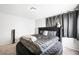 A bedroom featuring a tufted round bed and modern gray decor, with natural light from the nearby window at 5950 Pacific Shores Dr, Las Vegas, NV 89142