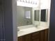 Bathroom featuring double sinks, wooden cabinets, and large mirror at 6416 Pronghorn Ridge Ave, Las Vegas, NV 89122