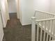 A hallway featuring brown carpet and a white railing at 6416 Pronghorn Ridge Ave, Las Vegas, NV 89122