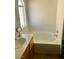 Bright bathroom featuring bathtub, vanity, and window with natural light at 6429 Rosemount Ave, Las Vegas, NV 89156