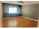 Bedroom featuring wood-look flooring, a window with blinds, and neutral walls at 6429 Rosemount Ave, Las Vegas, NV 89156