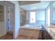Bright bathroom featuring a large tub, a glass shower, and a vanity with granite countertops at 7625 Spanish Bay Dr, Las Vegas, NV 89113