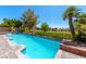 A stunning swimming pool surrounded by lush landscaping, brick accents and a distant view of a golf course at 7625 Spanish Bay Dr, Las Vegas, NV 89113