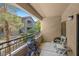 The outdoor balcony with seating and a bike offers a partial view of nearby landscaping at 8250 N Grand Canyon Dr # 1123, Las Vegas, NV 89166