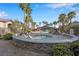 Community hot tub surrounded by a stone wall and lounge chairs at 8250 N Grand Canyon Dr # 1123, Las Vegas, NV 89166