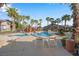Community pool with lounge chairs, palm trees, and a unique rock feature at 8250 N Grand Canyon Dr # 1123, Las Vegas, NV 89166