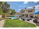 Landscaped backyard featuring a pool, patio, and well-maintained lawn at 8320 Opal Cove Dr, Las Vegas, NV 89128