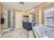 Bright bathroom featuring a double vanity, a jacuzzi tub and a glass shower with decorative tile at 8320 Opal Cove Dr, Las Vegas, NV 89128