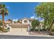 Charming two-story home with a red tile roof, lush landscaping, and a spacious three-car garage at 8320 Opal Cove Dr, Las Vegas, NV 89128