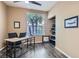 Functional home office with wood-look floors, a large window, and built-in shelving for storage at 8320 Opal Cove Dr, Las Vegas, NV 89128