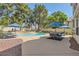 Backyard featuring a sparkling pool, lounge chairs and a dining area shaded by an umbrella at 8320 Opal Cove Dr, Las Vegas, NV 89128