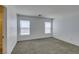 Bright bedroom with neutral walls, gray carpet, and natural light from two large windows at 8877 Perfect Diamond Ct, Las Vegas, NV 89129